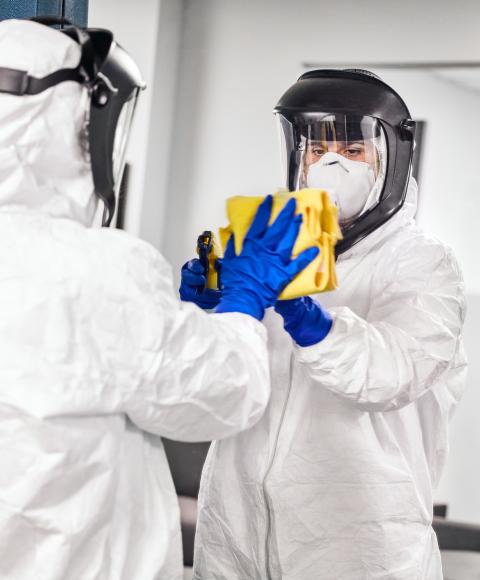 Aftermath technician in full PPE remediating and cleaning a home and office suspected of contamination