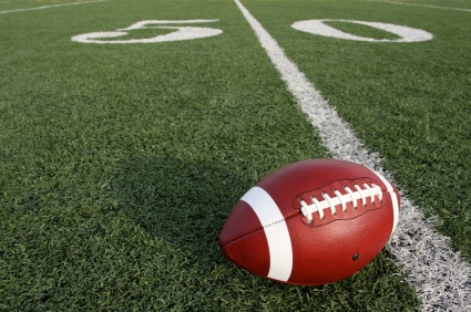 Football on 50 yard-line of football field.