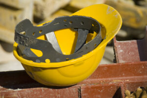Yellow hard hat sitting on beam after industrial accident.